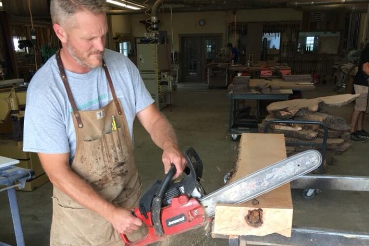 Gary Keener, co-owner of Keener & Schultz Fine Woodworks, cuts a piece of wood for a piece of furniture. The shop's Facebook page features their handmade work from start - as tree trunks - to finished designer furniture.